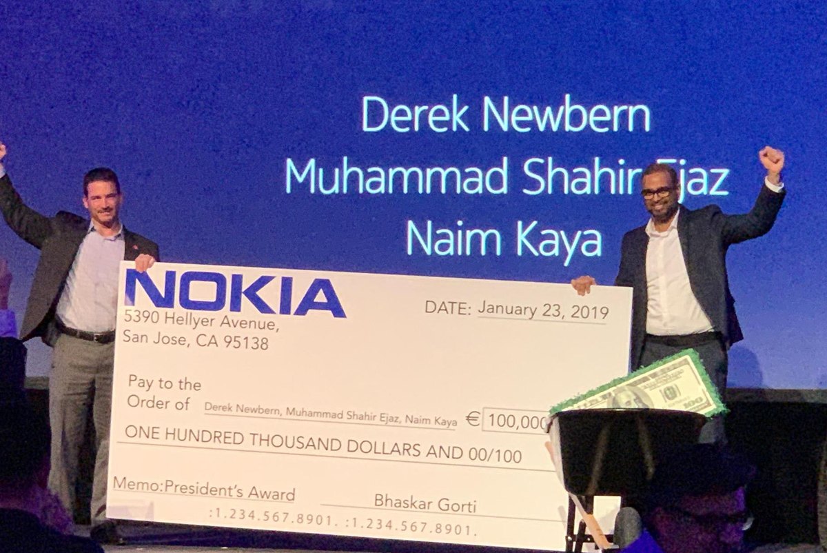 Derek Newbern with Nokia's President's Award check on stage, January 2019